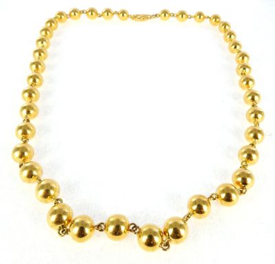 a close up of a gold necklace on a white background