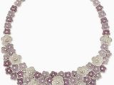 un gros plan d'un collier orné de fleurs violettes sur fond blanc