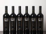 six bouteilles de vin sont alignées sur une table en bois