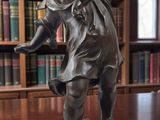 a statue of a boy holding a baseball bat on a table