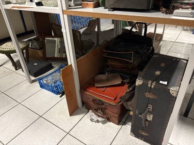 de nombreuses valises et cartons posés par terre dans une pièce