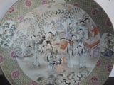 a plate with a painting of a group of people on it