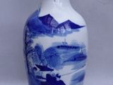 a blue and white vase sitting on a white surface