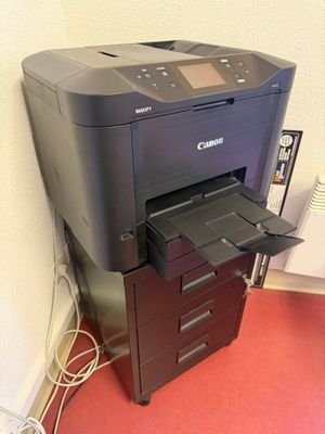 a printer that is sitting on top of a filing cabinet