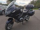 une moto noire garée sur un parking à côté de quelques voitures