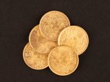 a close up of a pile of gold coins on a black background