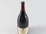 the bottle of wine is sitting on a white surface