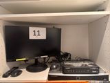 a computer monitor and other electronic equipment on a shelf