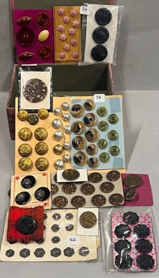 beaucoup de boutons dans une boîte posée sur une table