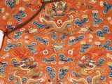 an orange jacket with a dragon on the front and a dragon on the back