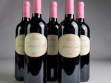 four bottles of wine are lined up in a row on a table