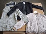 three jackets and a jacket are sitting on a cardboard box