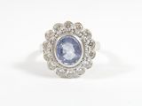 a close up of a ring with a blue sapphire surrounded by white diamonds