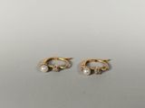 a pair of gold earrings with pearls on them
