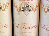 three bottles of red wine are lined up on a table