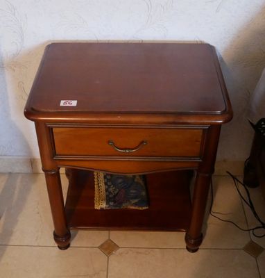 une petite table en bois sur laquelle est posé un magazine