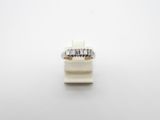 a close up of a diamond ring on a white surface