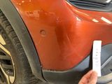 a person holding up a sticker to the front of a car