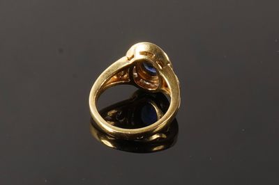 a close up of a gold ring with a blue stone in it