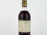 une bouteille d'alcool posée sur une surface blanche
