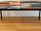 une table noire recouverte de carreaux orange et blancs