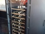 a wine cooler with many bottles of wine inside of it