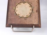 a small wooden box with a metal ring on it
