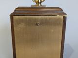brass plated clock with wooden case and brass ring on top