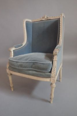 une chaise bleue et blanche sur laquelle est posé un coussin bleu