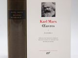 the book is sitting next to a book with a picture of karl marx on it