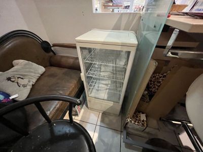 un petit réfrigérateur dans un coin de la pièce, à côté d'une chaise