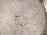 an image of a close up of a silver plate with a stamp on it