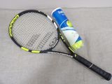 une raquette de tennis et une balle de tennis posées sur un canapé