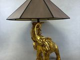 une lampe éléphant dorée avec un abat-jour sur le dessus