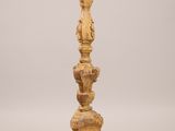 a tall wooden candle holder with a candle on top of it