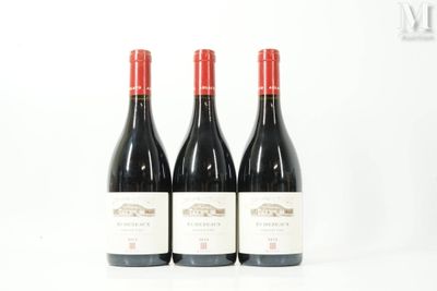 trois bouteilles de vin rouge posées côte à côte sur une table