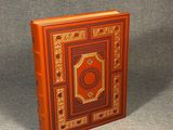 an orange book with a gold and red cover on a gray surface
