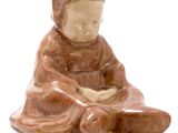 figurine of a woman sitting on her knees with a hat on