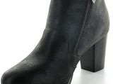 La femme porte une botte noire avec une fermeture éclair sur le côté.