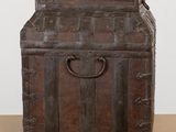 an old wooden trunk sitting on top of a table next to a white wall