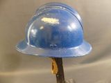 a blue hard hat on top of a wooden stick