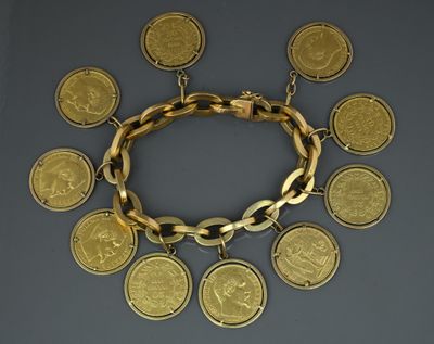 a close up of a gold bracelet with coins on it