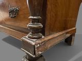 a wooden dresser with a metal knob on it
