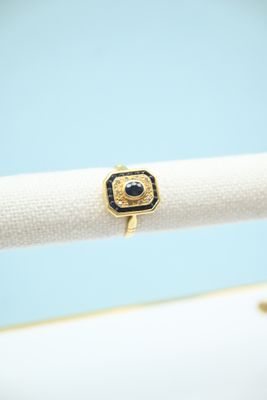 a close up of a gold ring with a black stone on it