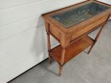 a small wooden table with a glass top on it