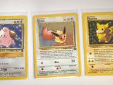 three pokemon cards are sitting on a table with a white background