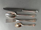 three silver spoons and a knife on a table with a knife in the middle