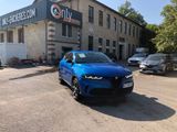 une voiture bleue garée devant un bâtiment dans un parking