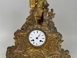 une horloge en or surmontée d'une statue d'homme