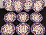 six blue and orange plates with designs on them sitting on a table
